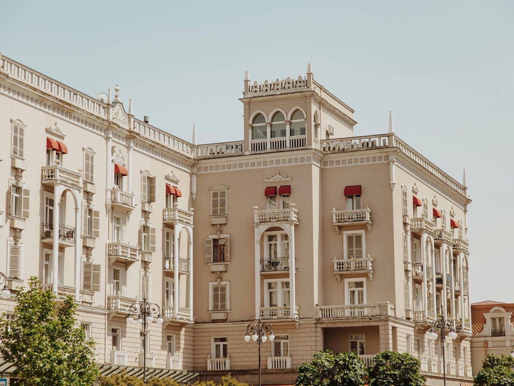 Edificio histórico elegante de fachada beige con balcones ornamentados y arcos, representando un legado patrimonial basado en valores: preservar la riqueza familiar mediante fideicomisos, fundaciones e inversiones sostenibles para generaciones futuras.